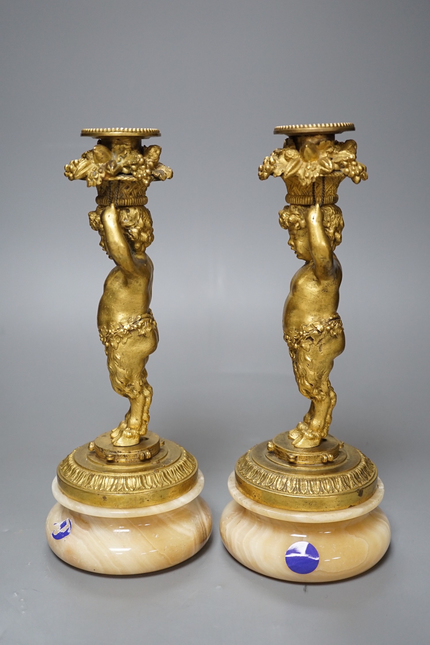 A pair of French gilt metal and onyx Bacchic faun candlesticks, 25.5 cms high